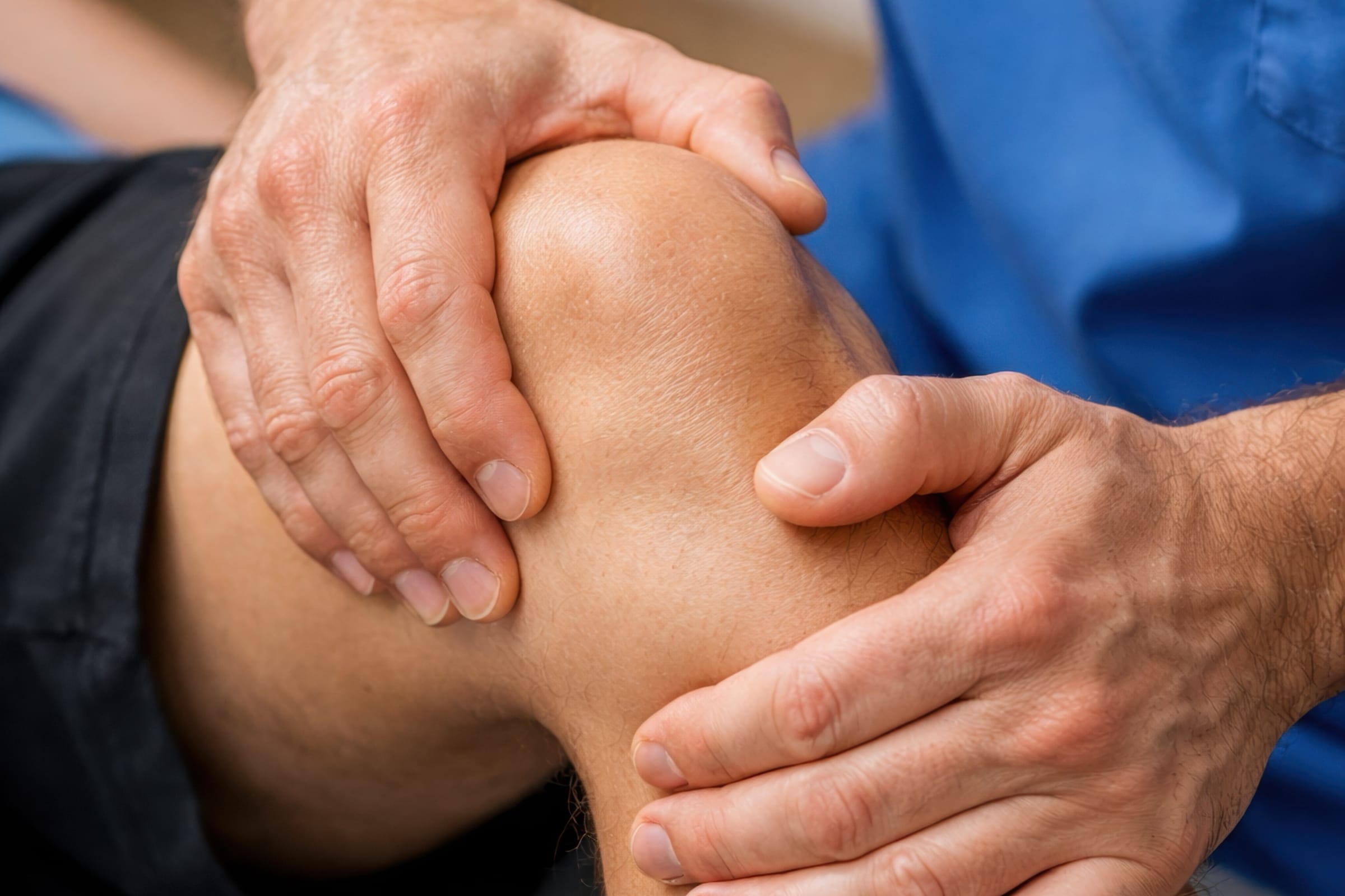 Fisioterapeuta explorando la rodilla de un paciente