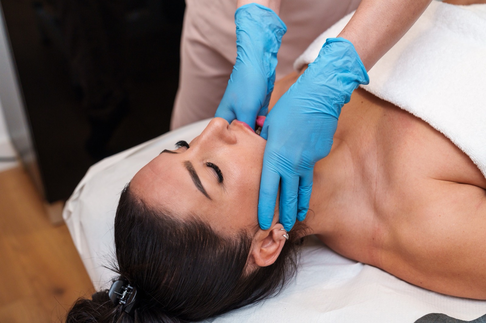 Fisioterapeuta aplicando tratamiento manual en articulación temporomandibular en FisioEGE Las Palmas