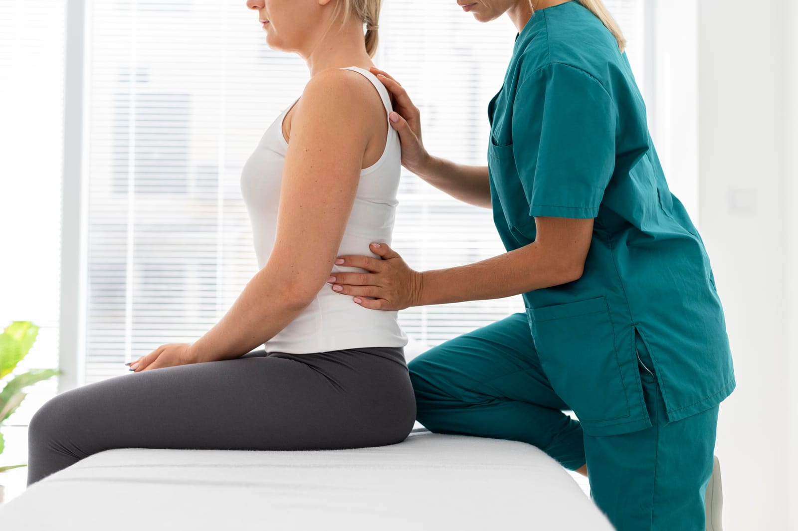 Fisioterapeuta valorando la columna de una paciente con dolor de espalda en FisioEGE Las Palmas