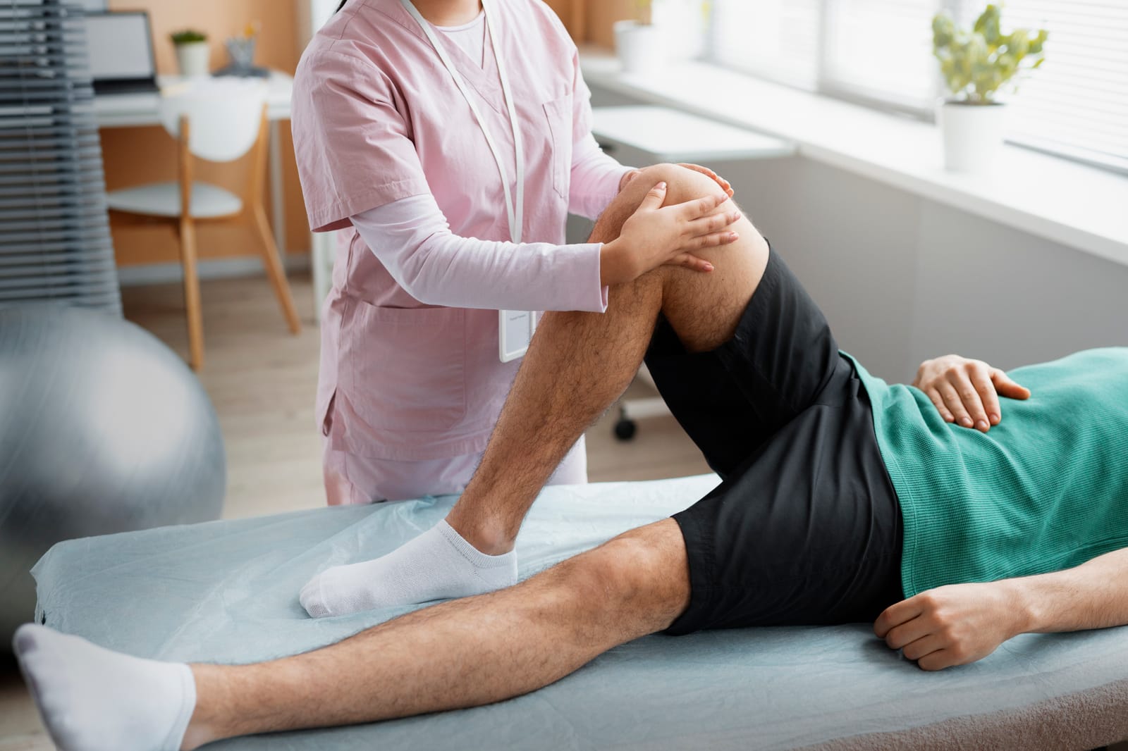 Fisioterapeuta movilizando la rodilla de un paciente en rehabilitación en FisioEGE Las Palmas